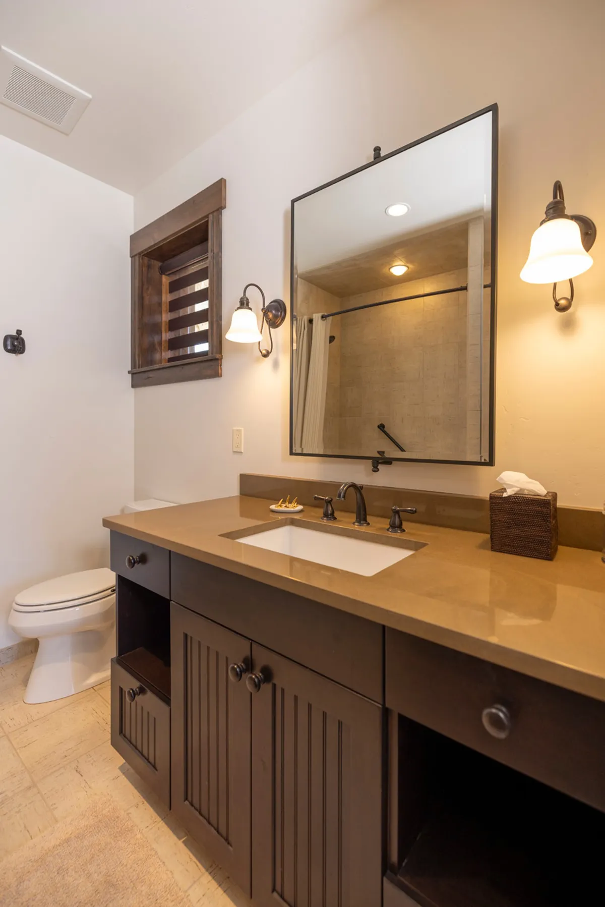A modern bathroom with a vanity sink, mirror, lighting fixtures, and a spacious shower area. The clean, calming design signals both style and functionality.